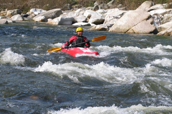 a man riding a surfboard on a raft in a body of water