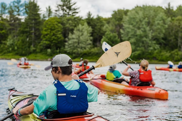a group of people rowing a boat in the water