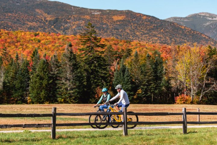 a person sitting on a bench in front of a mountain