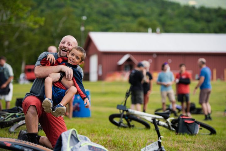 a group of people sitting around a mountain bike trail