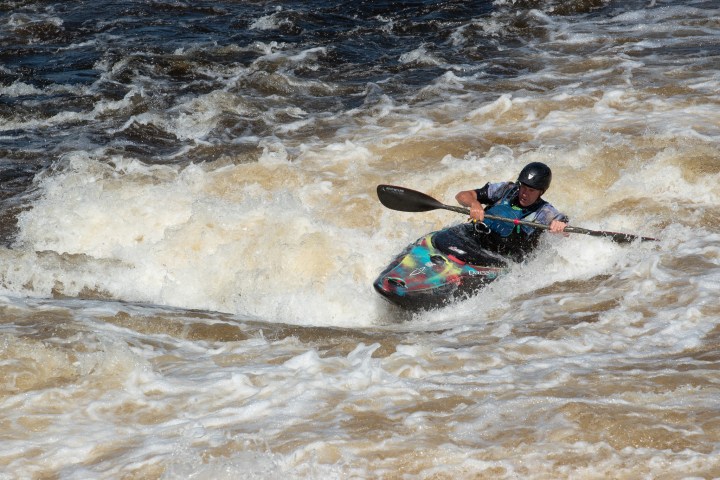 a man riding a wave on a surf board on a body of water