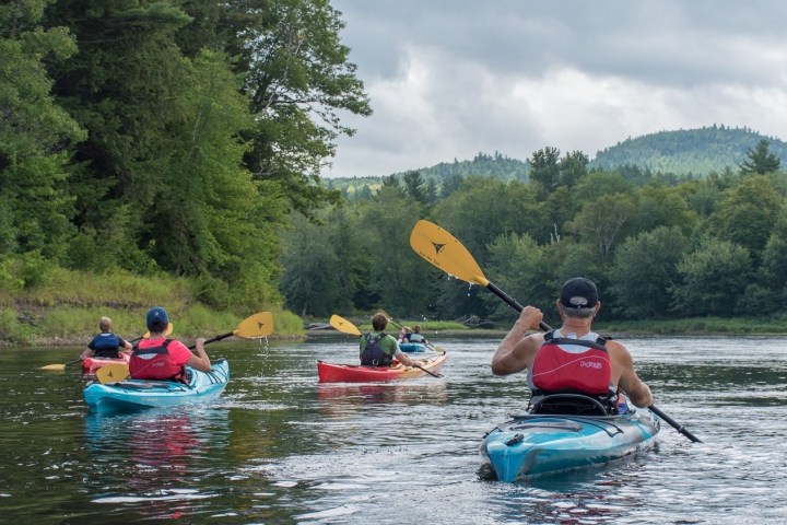 a group of people riding on the back of a boat in the water