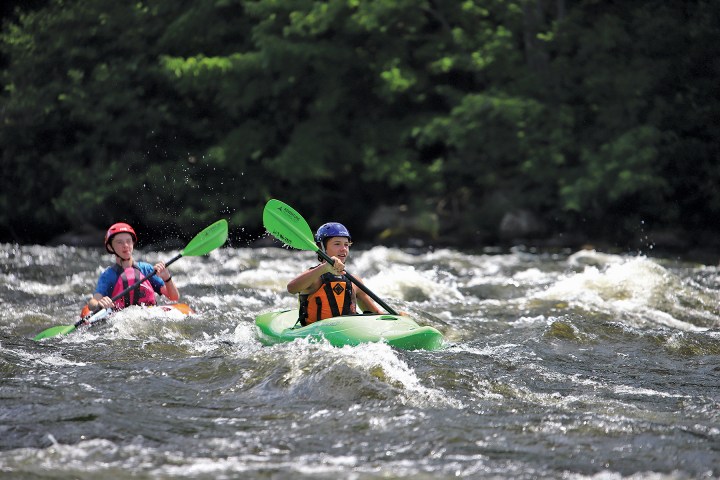 a man riding a wave on a raft in a body of water