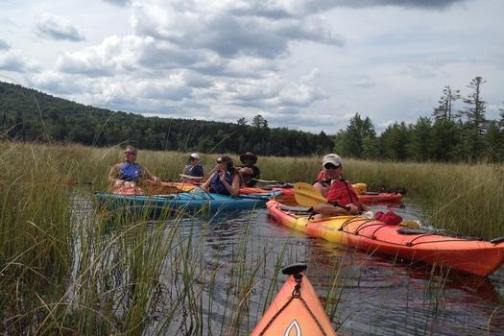 a group of people in a small boat in a body of water