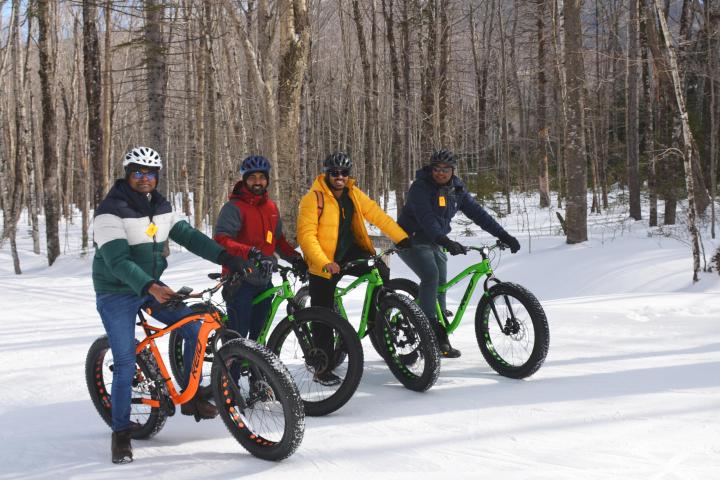 a person riding a motorcycle on the side of a snow covered forest