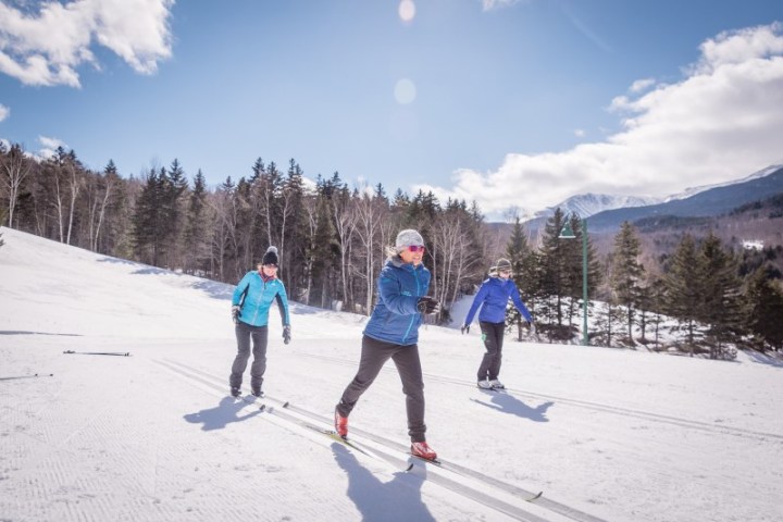 a group of people riding skis down a snow covered slope