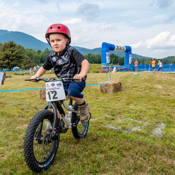 a young child riding on the back of a bicycle