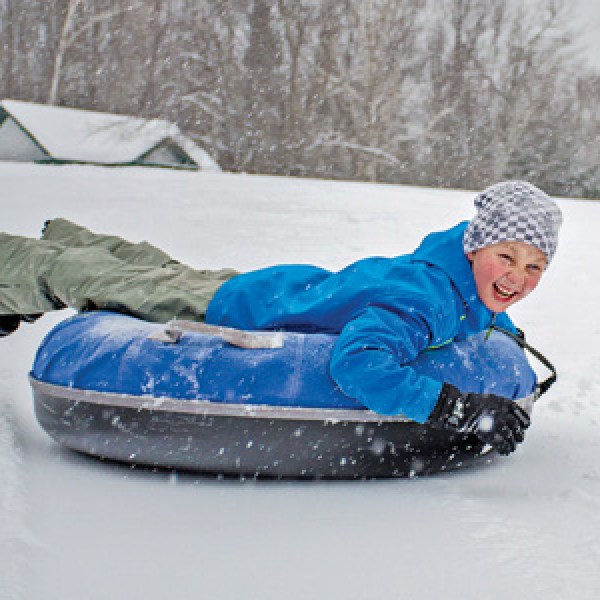 a person riding a snowboard down a snow covered slope