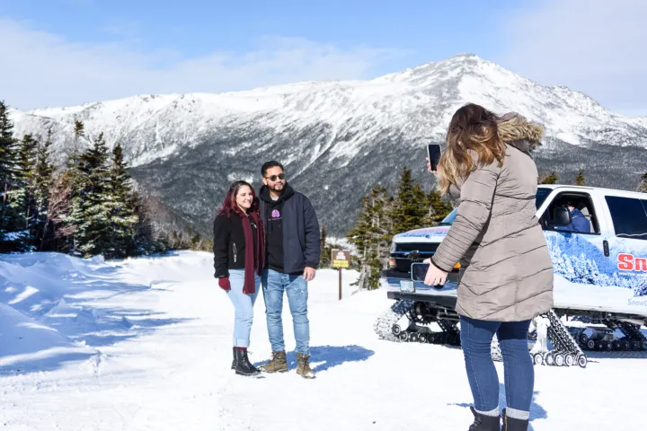 a group of people standing on top of a snow covered mountain