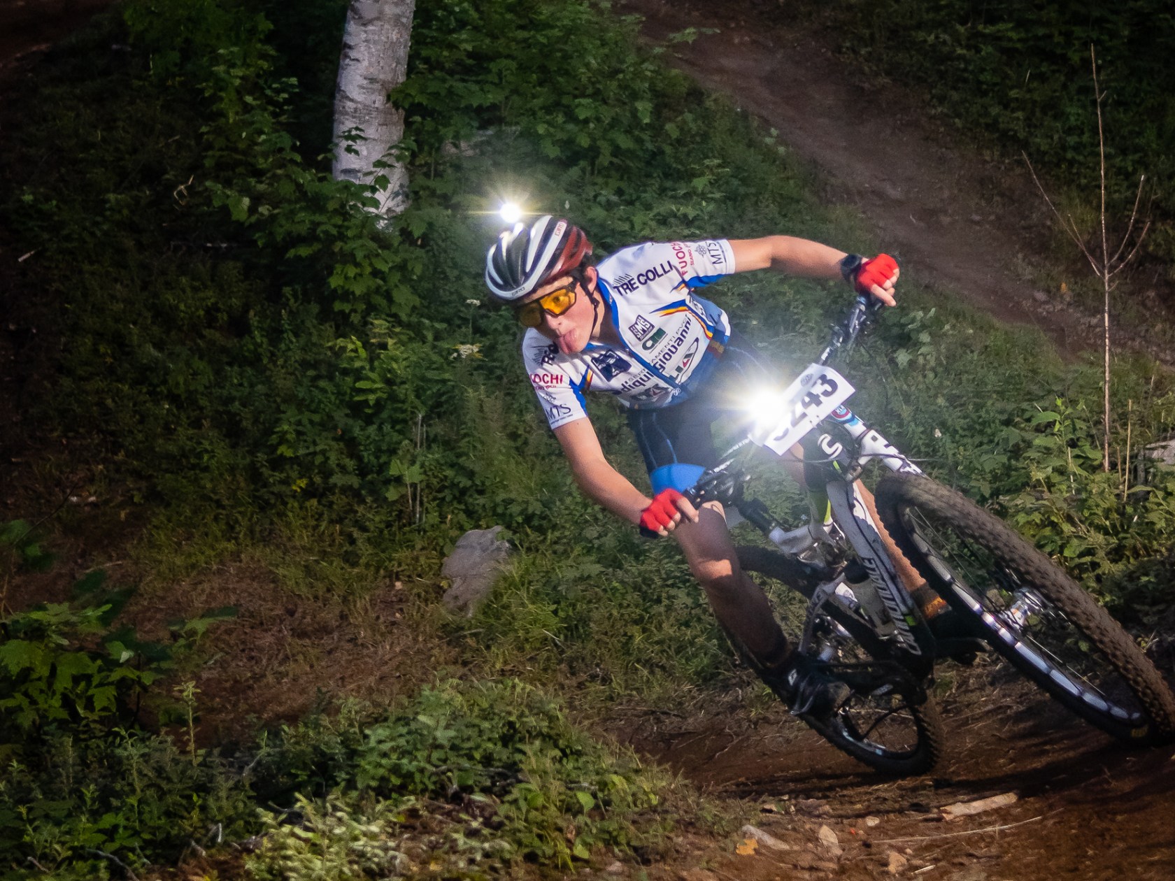 a man riding a bike down a dirt road